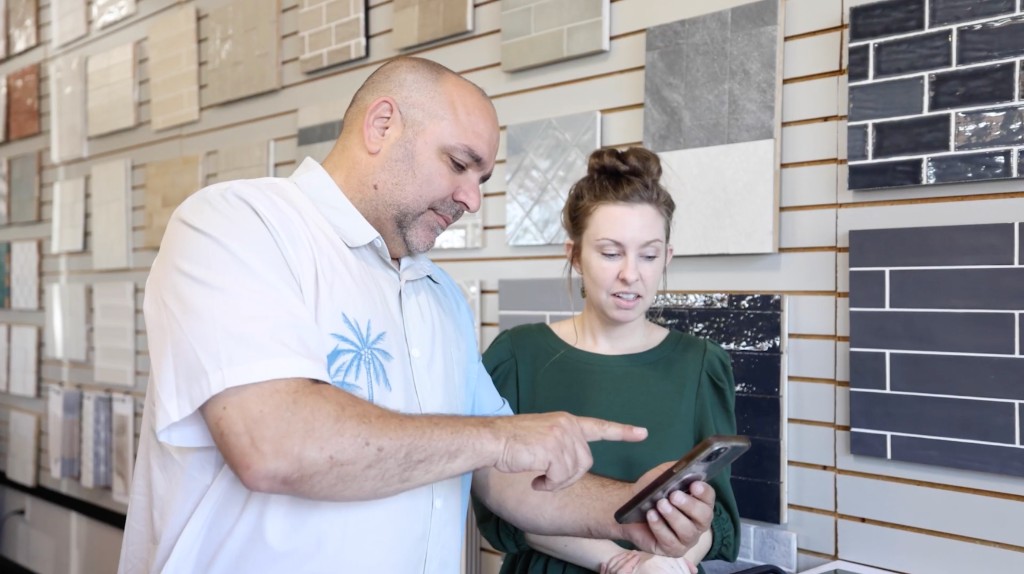 Showroom team members reviewing options together in front of a tile sample wall
